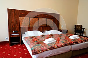 Cozy bedroom in vintage classic style in house, hotel, apartment, guest house. Double bed, white pillows and bedding, red duvet