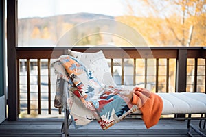 cozy blankets on log cabin balcony bench