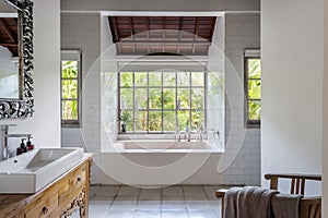 Cozy bright bathroom interior with built bathtub