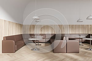 Cozy cafeteria interior with brown leather sofa and round table in row