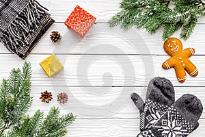 Cozy christmas evening. Cookies, spruce branch, knitten mittens on white wooden background top view copyspace