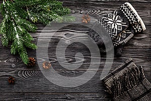 Cozy christmas evening. Knitten mittens and scarf on grey wooden background top view copyspace