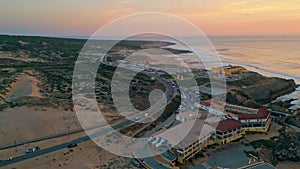 Cozy coastal resort evening twilight aerial view. Ocean waves washing coastline