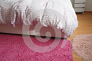 Acogedor compacto dormitorio blanco muebles rosa alfombra a tul cortinas. esponjoso frazada llamadas salientes a través de dos veces una cama 