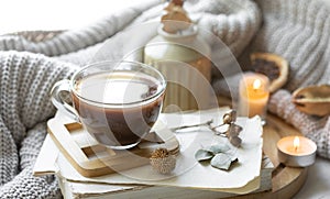 Cozy composition with a cup of tea, books and a knitted element.