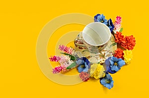 Cozy composition, design, tea set and decorative flowers on a yellow background, copy space