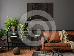 Cozy composition of living room interior with mock up poster frame, brown sofa, plants, glass sideboard, stool, wooden floor,