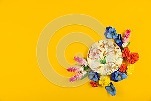 Cozy concept, yellow isolated background, saucer with flowers, top view and copy space