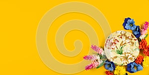 Cozy concept, yellow isolated background, tea party set with flowers, top view and copy space banner