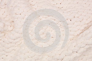 Cozy cream colored knitted thick wool blanket, full wavy background