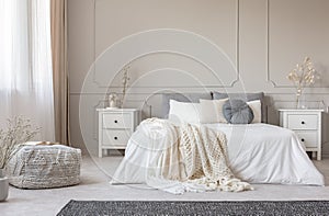 Cozy cream colored woolen blanket on king size bed in bright bedroom