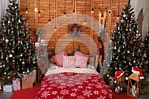 Cozy decor in the interior of the New Year's room, Christmas tree, garlands, gifts, bed. Festive atmosphere in the