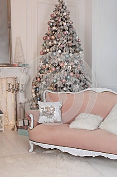 Cozy decorated room for Xmas. Decorated Christmas tree with gifts, fireplace and sofa. Christmas room interior home. Stylish inter