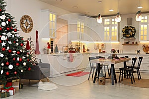 Cozy dining room interior with Christmas tree and beautiful festive decor