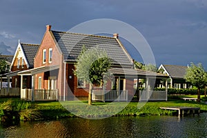 Cozy Dutch holiday home at lake in sunlight at evening