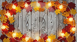 Cozy fall background with leaves and rustic string lights
