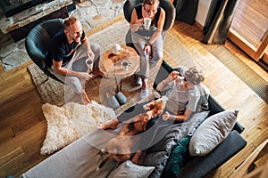 Cozy family tea time. Father, mother and son  at the home living room. Boy lying in comfortable sofa and  stroking their beagle