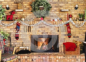 Cozy fire in brick fireplace and mantle decorated for Christmas