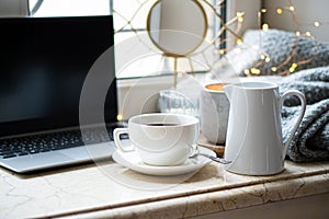 Cozy freelancer`s winter work place at home with cup of coffee photo