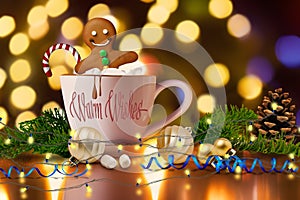 Cozy gingerbread man soaking in cup of hot cocoa with marshmallow photo