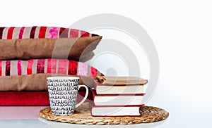 Cozy home interior decor: cup of coffee, stack of books, pillows and plaid on a white table. Distance home education. Quarantine