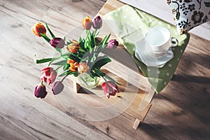 Cozy home spring atmosphere - vase with colorful tulips on wooden chair