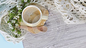 Cozy home still life: cup of hot coffee, spring flowers and opened book with warm plaid. Springtime concept, free copy