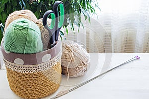 Cozy homely atmosphere. Balls for knitting in natural colors. Female hobby knitting.