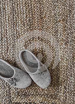 Cozy homemade felt homemade beige slippers on a jute rug top view