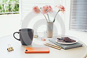 Cozy interior details. Little round table with cup of delicious earl gray tea. Resting after work day, drinking tea and eating