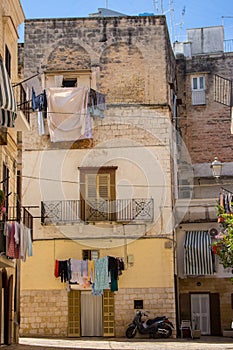 Cozy italian backyard with balcony, drying clothes and motorcycle. Traditional mediterranean architecture. Italian town landmark.