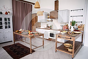 Cozy kitchen with food , bright kitchen with tables with food, there are dishes on  tables, large selection of food, festive