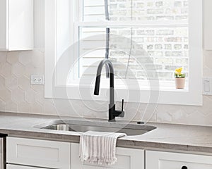 A cozy kitchen sink detail with a hexagon backsplash.