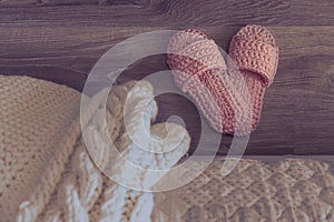 Cozy knitted slippers beside the bed. Night bedroom. White knitted plaid on the bed