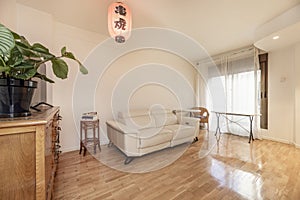 Cozy living room with classic wooden furniture, marble table with wrought iron base, glossy oak parquet floors and a white leather