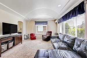 Cozy living room interior with black leather couch and tv set