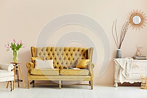 Cozy living room interior of retro armchair, vintage wooden chest dwarf and vintage couch on the background of the beige