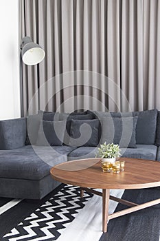 Cozy living room with navy blue satin sofa and candles on wood t