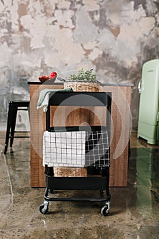 Cozy loft kitchen with dinning table, chairs and metal storage racks on wheels - trolley