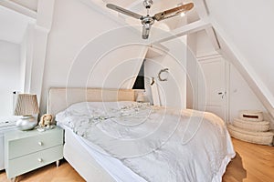 Cozy mansard bedroom with big bed