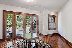 Cozy modern interior design of a living room with laminate flooring and big windows in a mansion