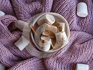 Cozy mood lifestile, still life concept. Mug of aromatic cacao, sweater and cinnamon on pink knitted sweaters as