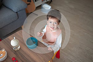 Cozy mornings: Multiracial toddler enjoying biscuits in pajamas