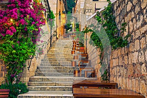 Narrow street and street cafe decorated with flowers, Hvar, Croatia photo