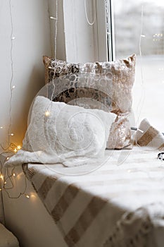 Cozy Pillows on Window Seat with Warm Lights