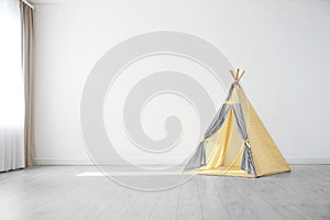 Cozy play tent for kids as element of nursery interior in empty room