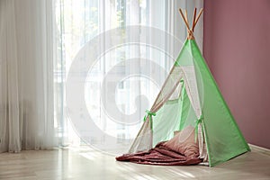 Cozy play tent for kids near window in room