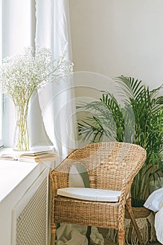 Cozy reading nook by the window with rattan wicker chair