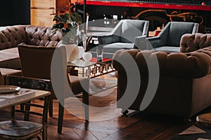 Cozy restaurant interior with modern armchairs and table with flowers
