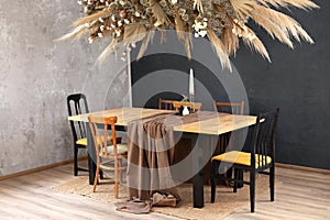 Cozy room decorated with fall decor. Stylish dinning room with wooden table and chairs. Holiday family dinner. photo